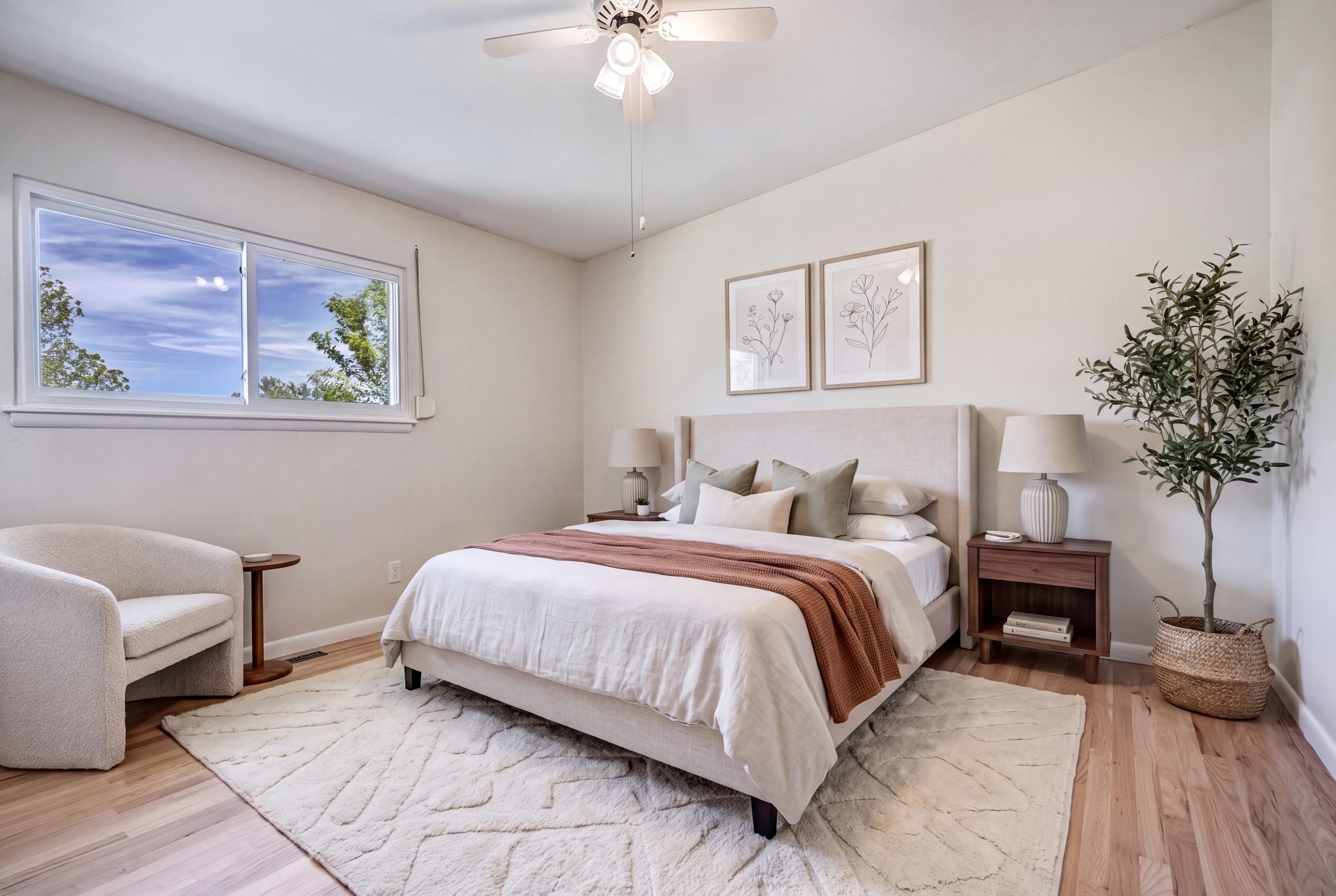 Main-level primary bedroom, staged with a queen bed and olive tree